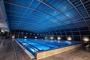 An indoor swimming pool with a high, arched ceiling and clear water. - Piano Monaco (Carini)