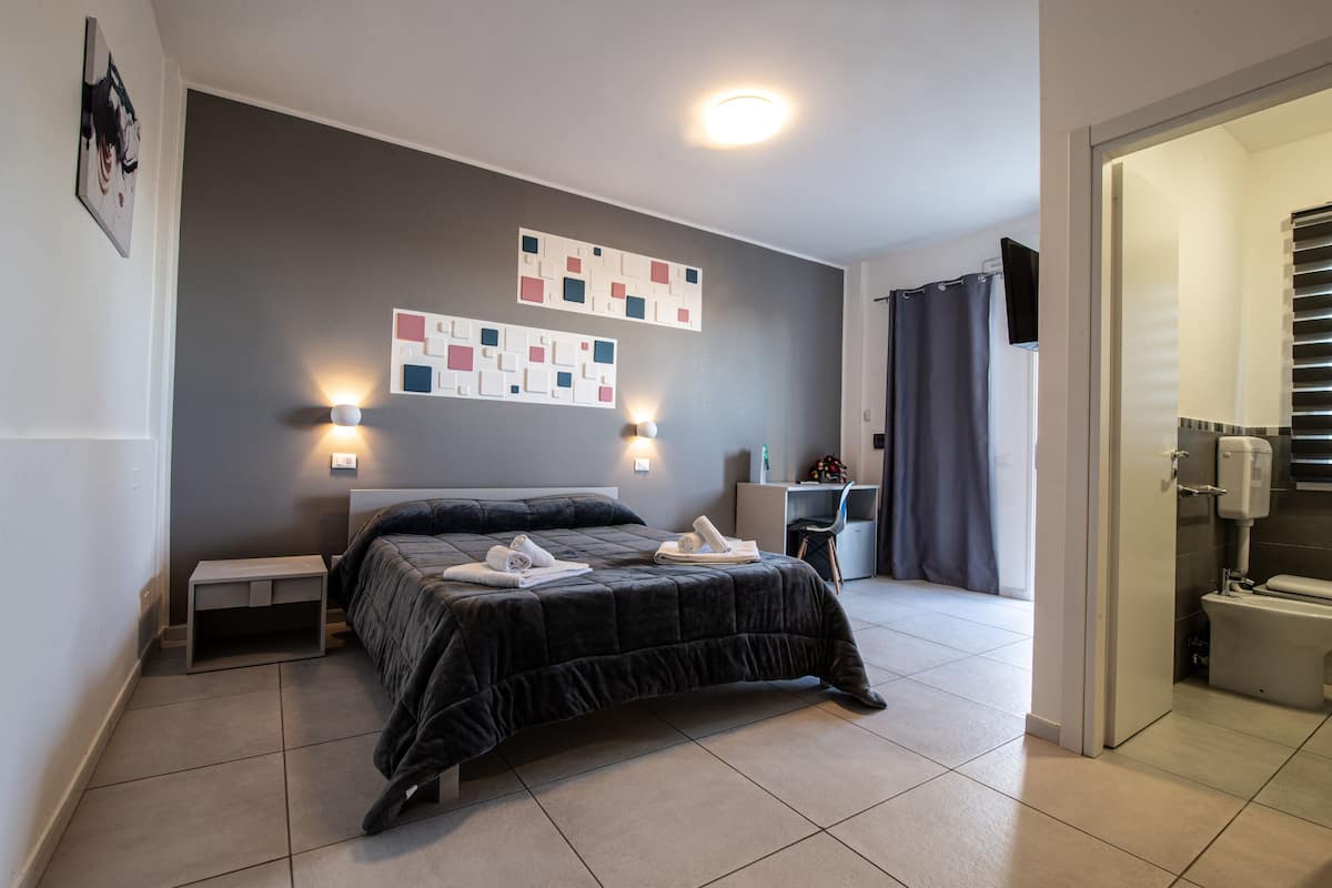 Une chambre à coucher moderne avec un lit, des tables de chevet et un bureau.