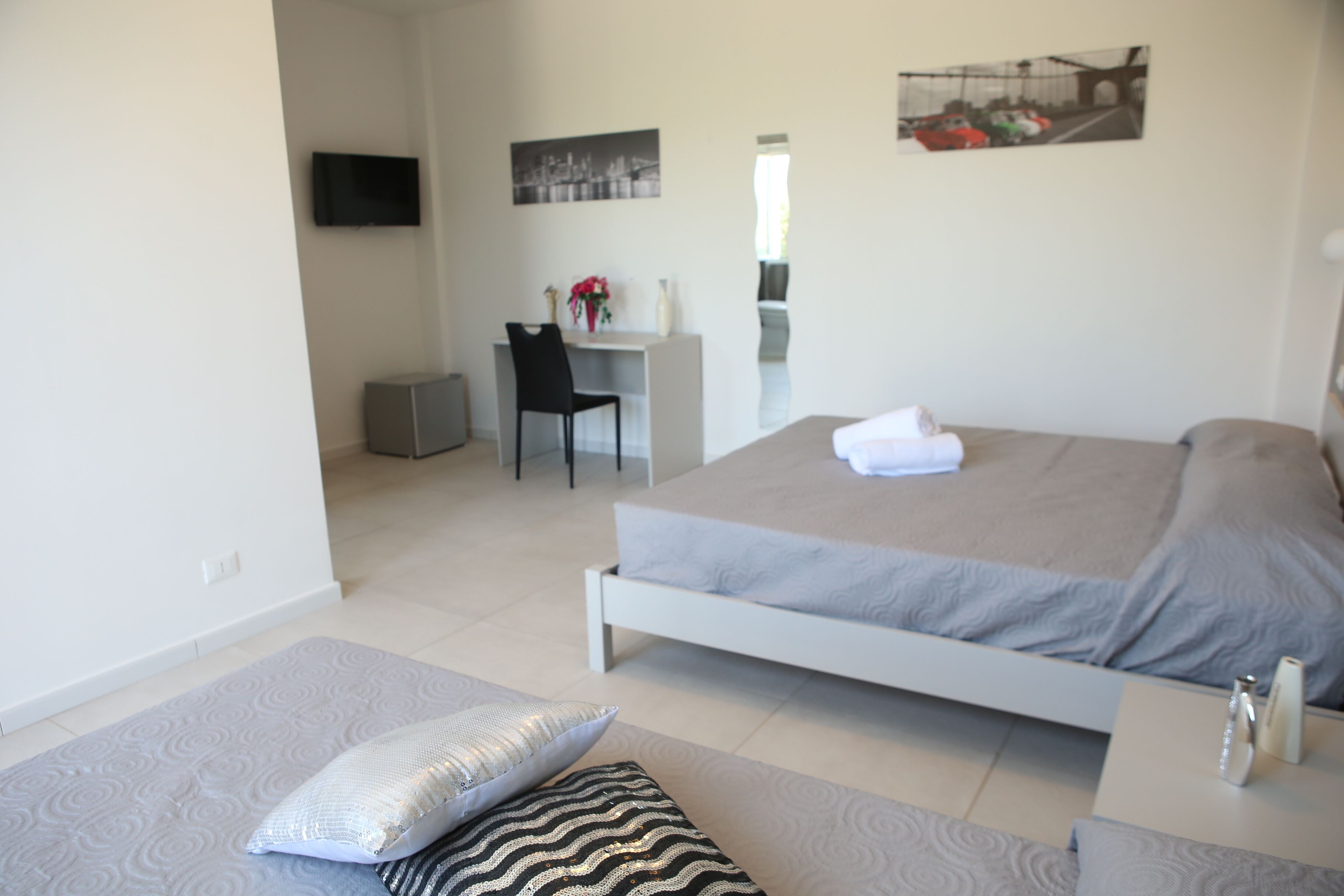 Een moderne hotelkamer met een bed, een bureau en een stoel.
