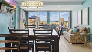 Un comedor con una mesa y sillas, un sofá y vistas al exterior.