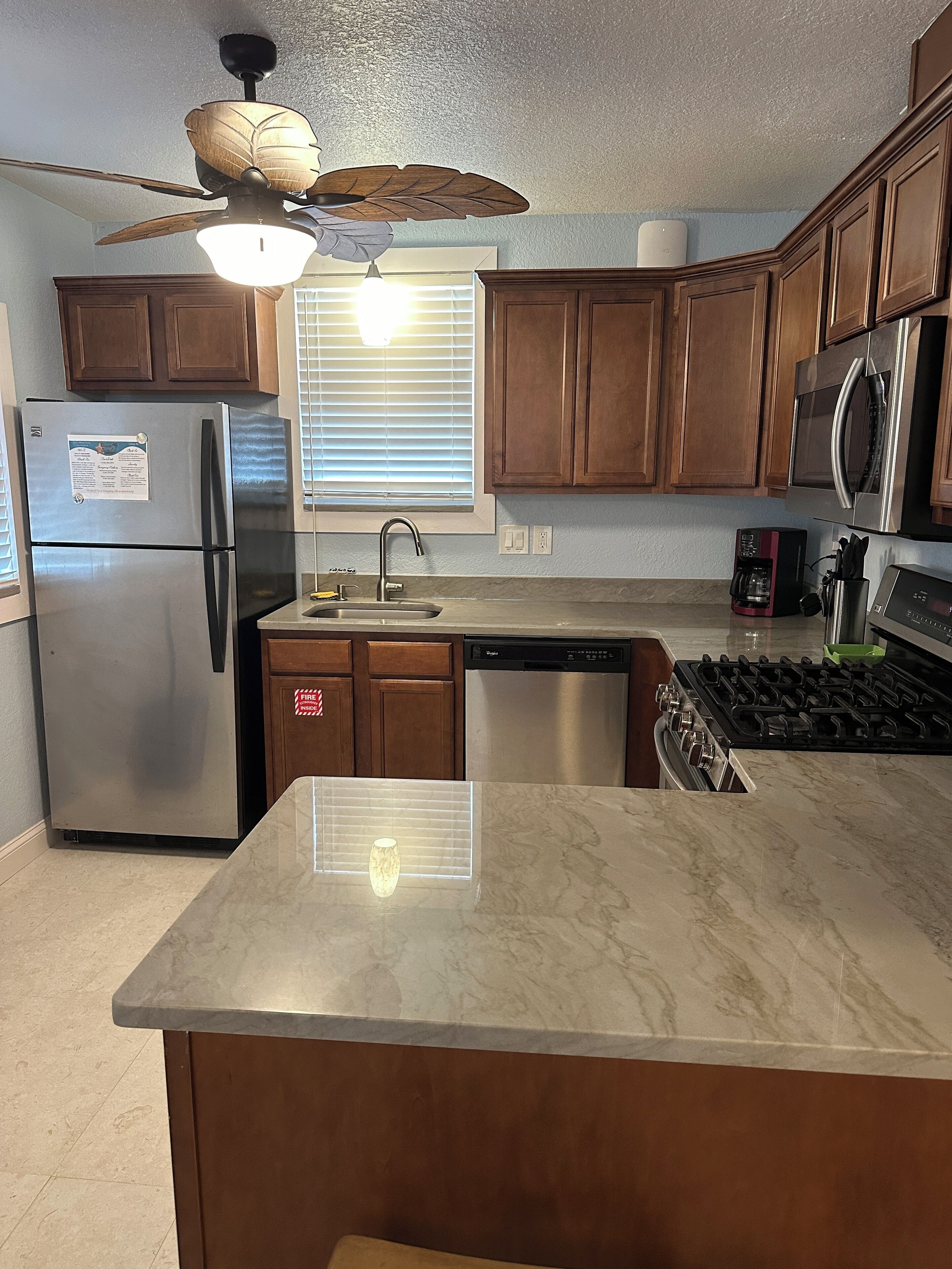 A kitchen with a refrigerator, stove, dishwasher, and wooden cabinets.