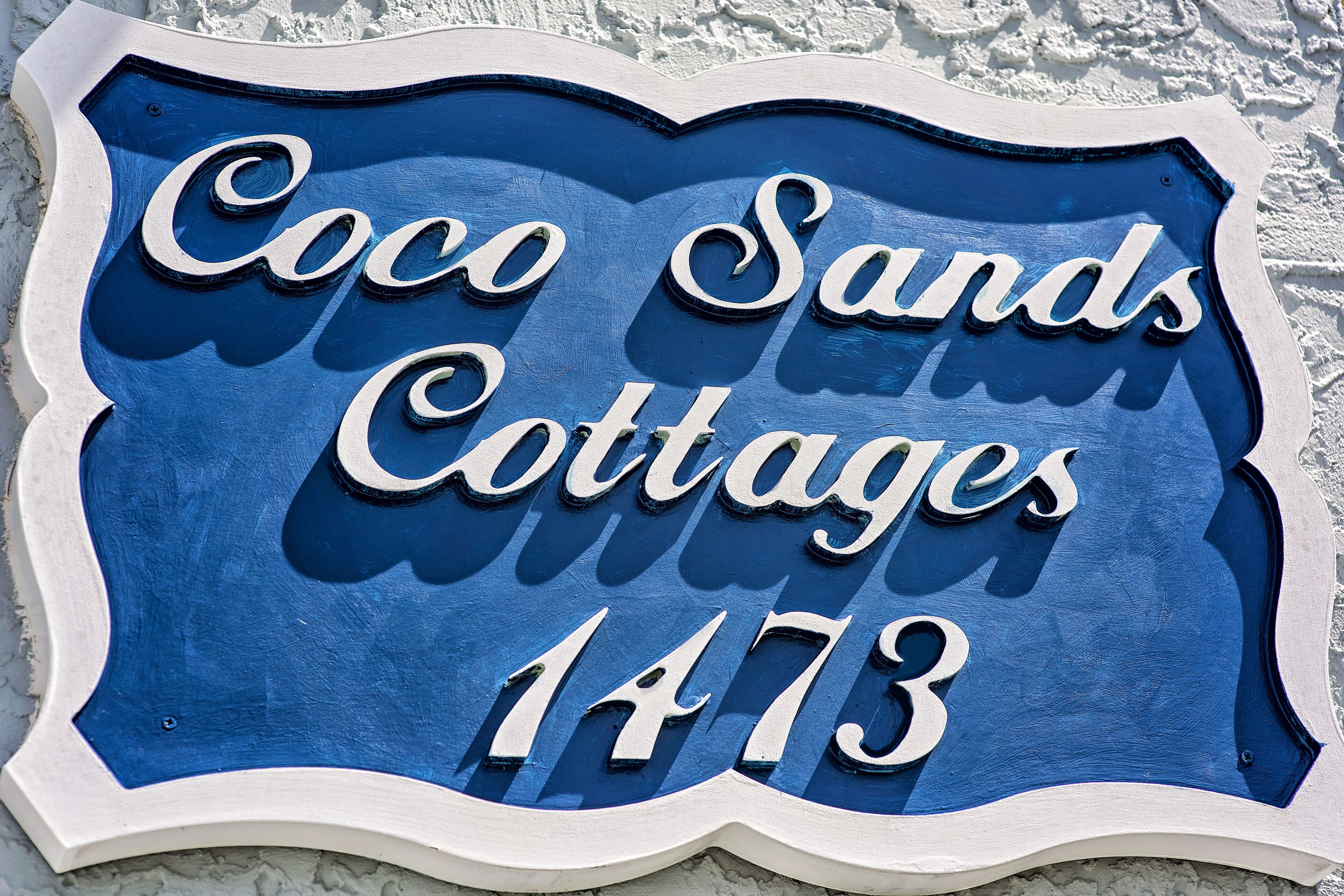 A sign for Coco Sands Cottages with the number 1473.