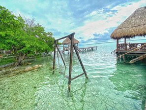 Escape to a serene overwater bungalow surrounded by lush greenery and calm waters.