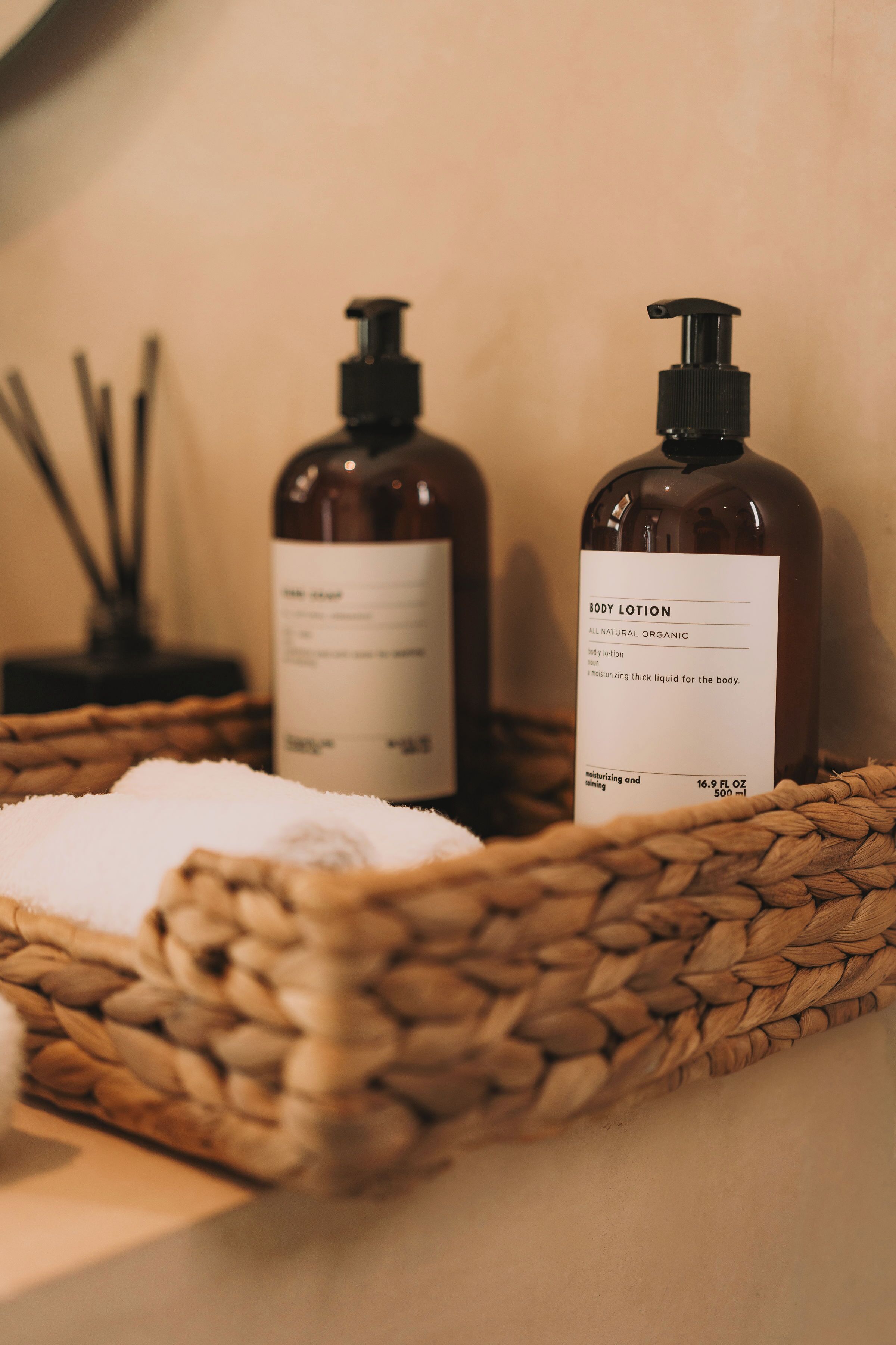 Two bottles of body lotion in a woven basket.