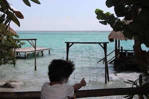 Guests can enjoy a tranquil beachside setting with a picturesque pier and lush surroundings.