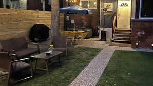 A backyard with a patio area, outdoor furniture, a barbecue grill, and a tree. - 6 Bedroom/4.5 Bath/Across from Motown Museum (Detroit)