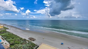 A beach with a wooden pier, a pool, and a view of the ocean. - Beachfront Resort Condo w/ Panoramic Ocean Views! (New Smyrna Beach)