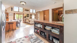 Una cocina amplia con muebles de madera, una isla central y un comedor con vistas al exterior.