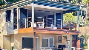 A houseboat with a deck, outdoor seating, and a kitchen area. - The Deckhouse, Cottage Point. Waterfront Adults Retreat. (Cottage Point)