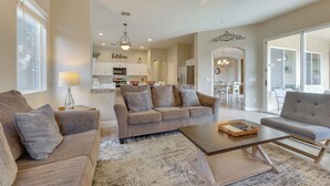 A spacious living room with a sofa, armchair, and coffee table, connected to a kitchen and dining area. - 4 Mi to Riparian Preserve: Mesa Abode w/ Hot Tub (Mesa)