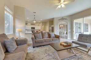 A spacious living room with a sofa, armchair, and coffee table, connected to a kitchen and dining area. - 4 Mi to Riparian Preserve: Mesa Abode w/ Hot Tub (Mesa)