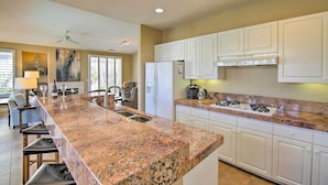 Eine moderne Küche mit Granit Arbeitsplatten, weißen Schränken und Edelstahlgeräten.