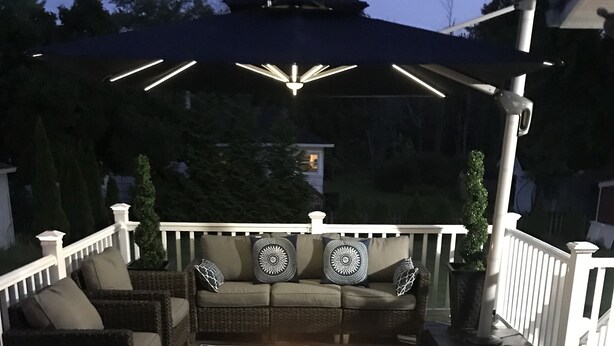 Terraza exterior con fogón, zona de estar e iluminación colgante.