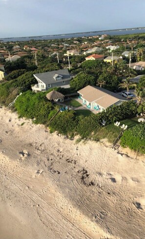 Una zona residencial costera con casas, una playa y una vista despejada del océano.