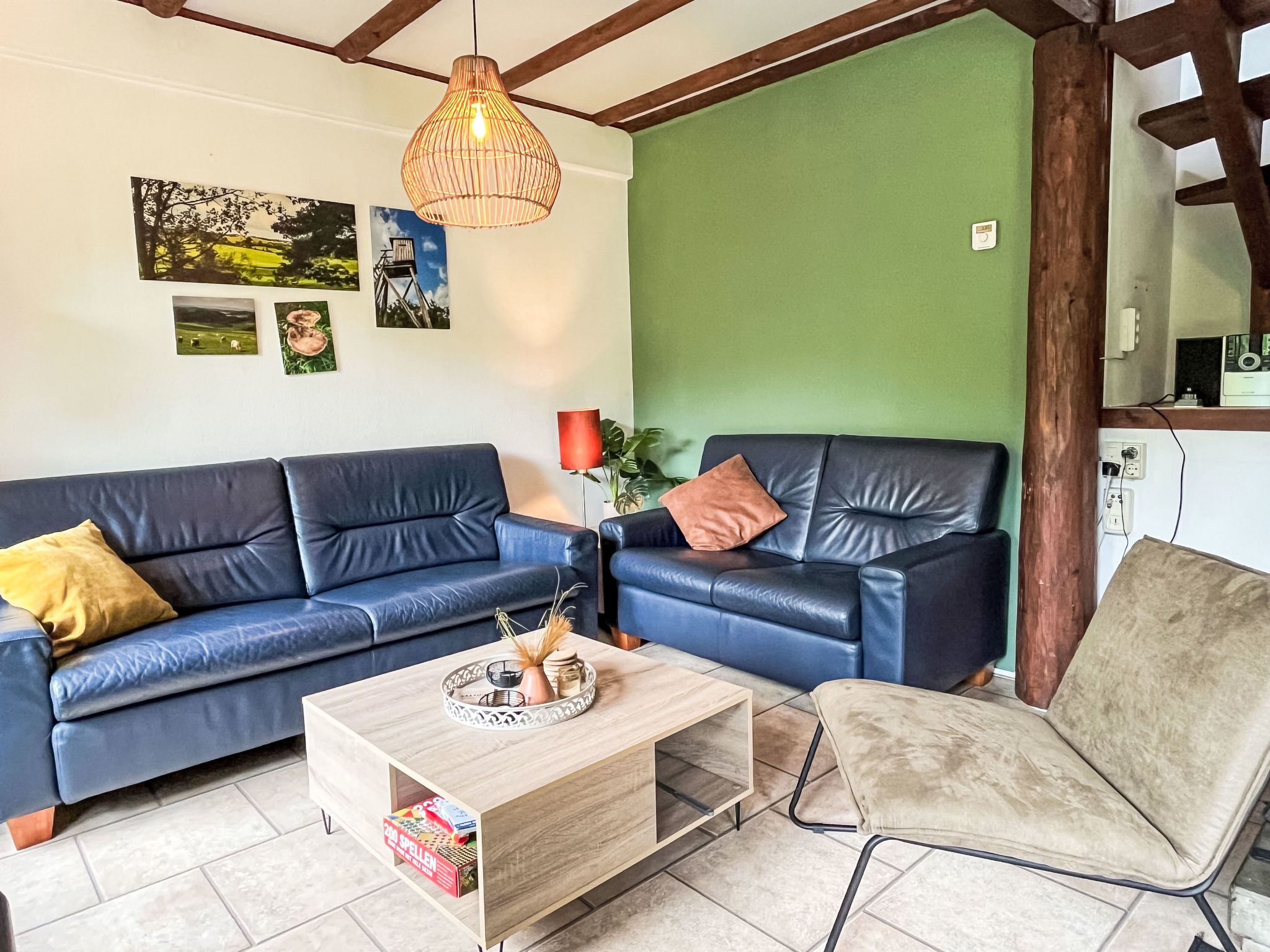 A living room with a blue sofa, a wooden coffee table, and a beige armchair.