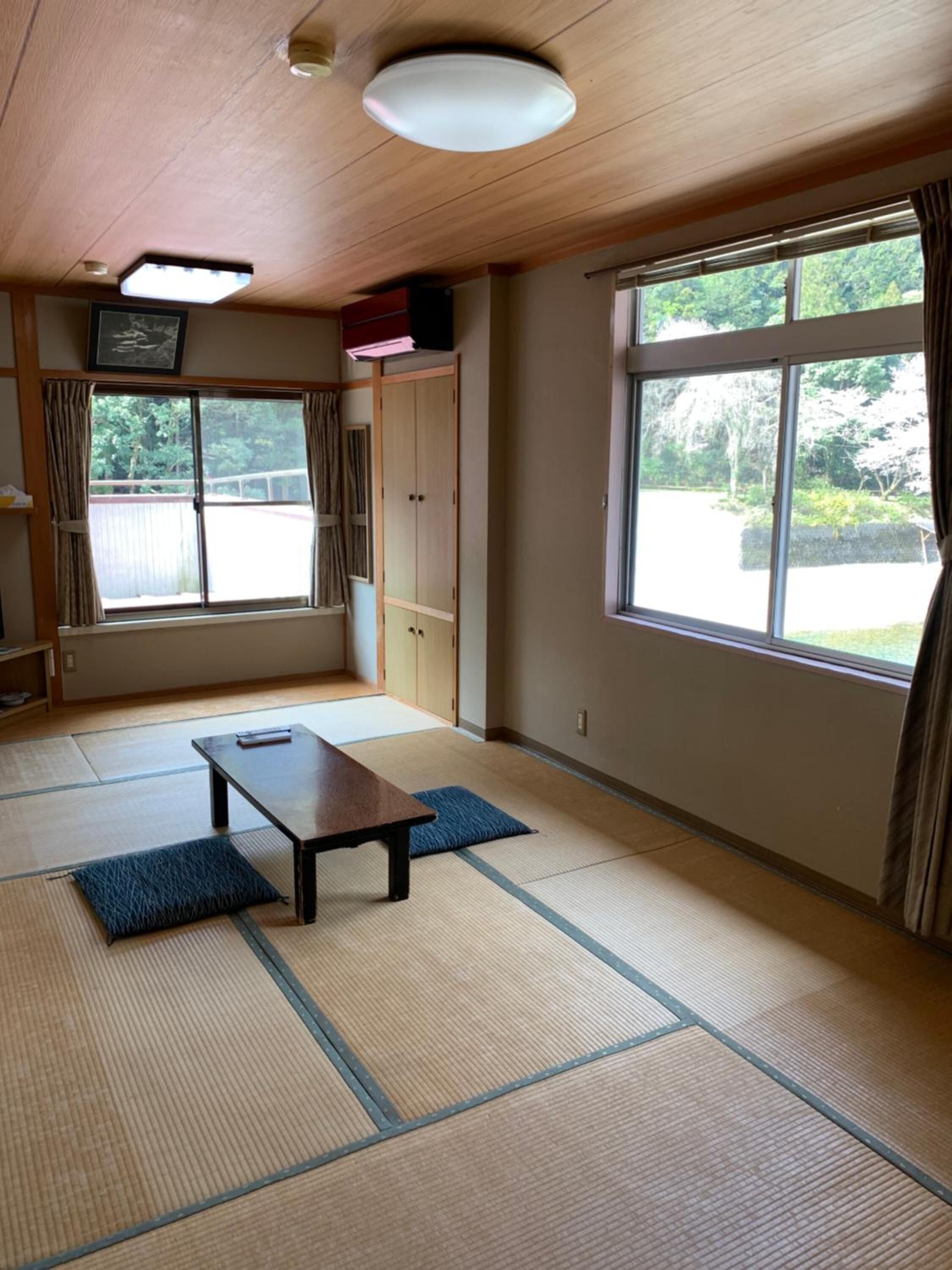 A traditional Japanese room with tatami flooring, a low table, and sliding doors.