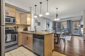 A modern kitchen with wooden cabinets, stainless steel appliances, and a central island.