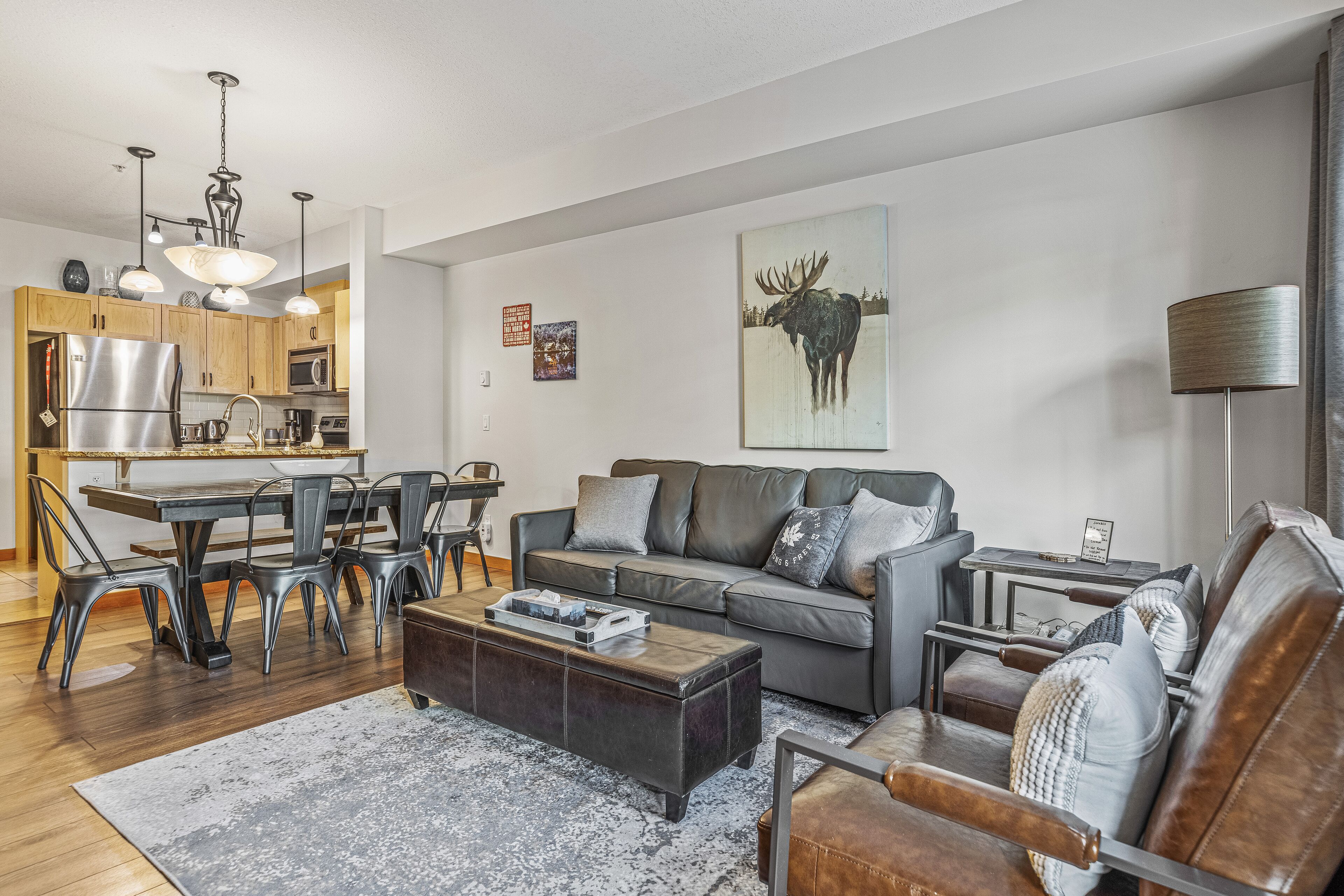 A modern living room with a sofa, coffee table, and dining area.