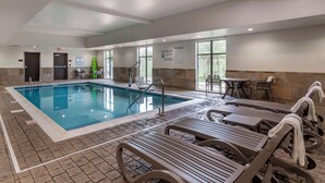 Un espace piscine équipé de chaises longues, d’un poste de surveillance pour les sauveteurs et d’un panneau indiquant qu’il est interdit de plonger.
