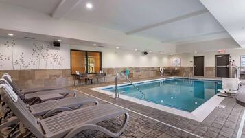 Una piscina techada, sillones reclinables de piscina
