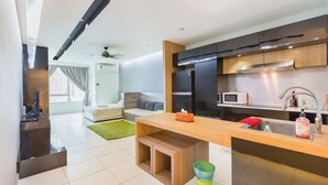 A modern kitchen with a wooden island, stainless steel sink, and a microwave. - Akademik Suites (Johor Bahru)
