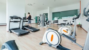 A gym with treadmills, an elliptical, and weight machines. - Akademik Suites (Johor Bahru)