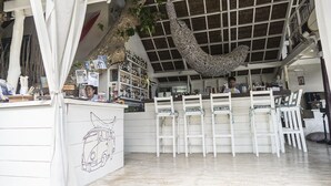 Eine Bar mit weißen Stühlen, einer Theke und einem hängenden Dekorationselement.