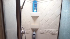 A shower stall with a hand soap dispenser, a shampoo bottle, and two bottles of lotion. - Near Blue Springs Pk (Orange City)