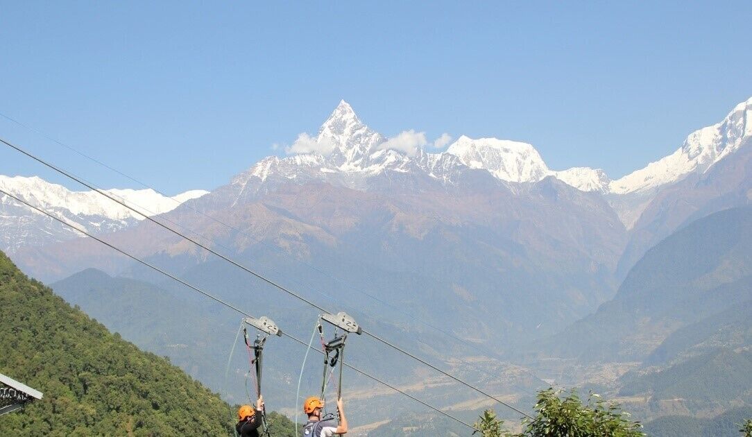 A mountain landscape with a clear sky and a cable car system.