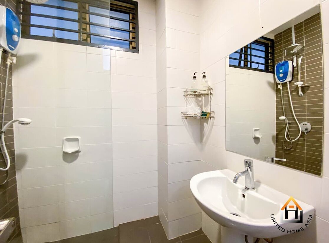 A bathroom with white tiles, a sink, a mirror, a shower, and a window with bars.