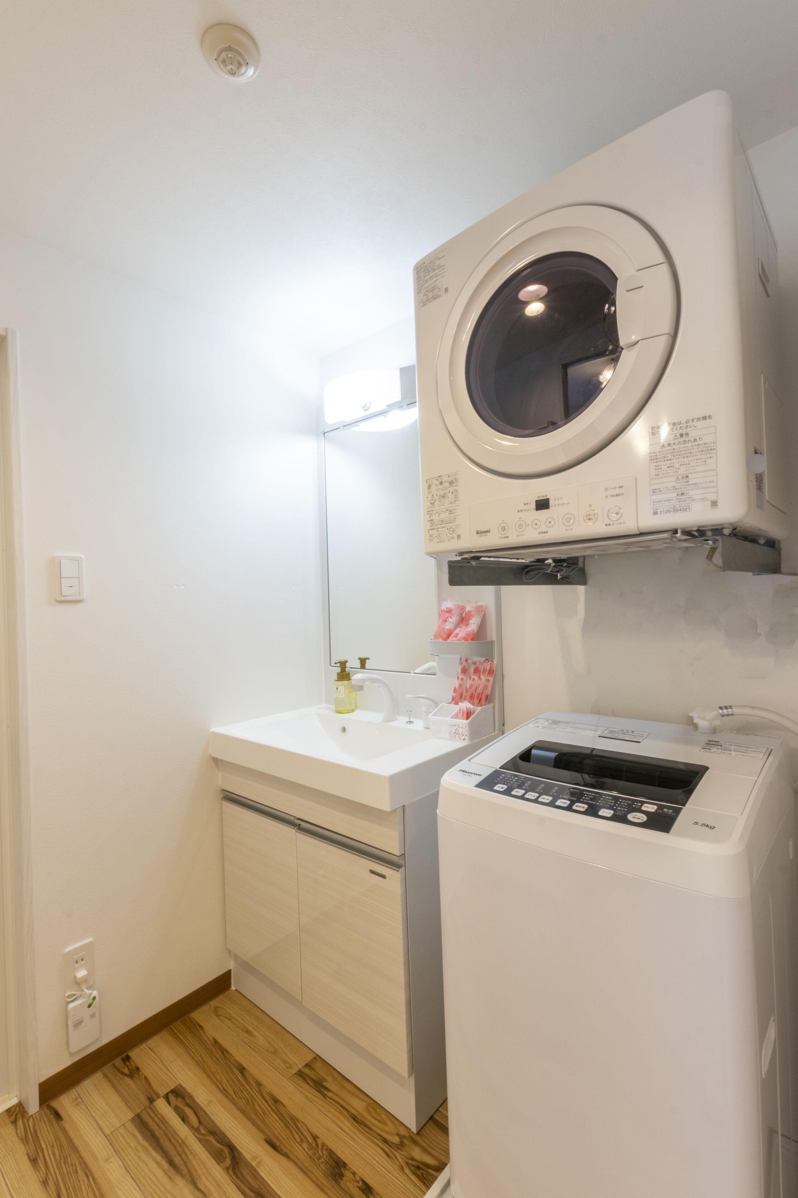 Une petite buanderie équipée d’un lave-linge, d’un sèche-linge et d’un évier.