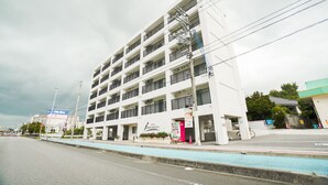 A multi-story hotel with a modern design, featuring balconies on each floor and a visible sign for the hotel. - Hotel Houklea (Nago)