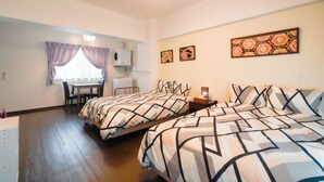 A hotel room with two beds, a desk, and a ceiling fan. - Hotel Houklea (Nago)