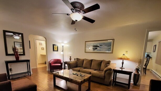 A living room with a ceiling fan, a brown sofa, a coffee table, and a red armchair. - 6 Adults, Dogs OK see below . Breakfast , Olympic Nat. Park, Victoria ferry (Port Angeles)