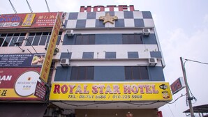 A hotel with a checkered facade, a prominent star logo, and contact information for booking. - OYO 44010 Royals Star Hotel (Seremban)
