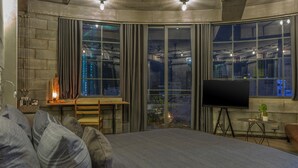 A modern bedroom with a large bed, a desk, and a TV. - Bridges Danang Boutique Hotel (Da Nang)