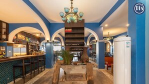 A bar area with a 'Welcome' sign, a chandelier, and a refrigerator. - Pi's Boutique Hotel (Sa Pa)