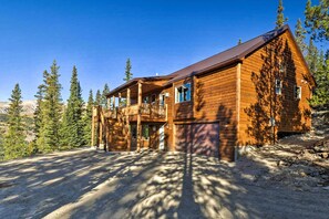 Une cabane en rondins avec un balcon et un garage.