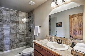 Une salle de bain moderne avec une douche en verre, un meuble-lavabo en bois et un grand miroir.