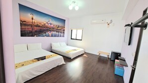 Habitación de hotel con dos camas, un cuadro grande de un paisaje urbano, una ventana, un escritorio y un pequeño banco.