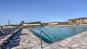 A swimming pool with lounge chairs and a metal handrail, surrounded by buildings and trees. - Relax by Pool & Walk to Beach: Hilton Head Condo! (Hilton Head Island)
