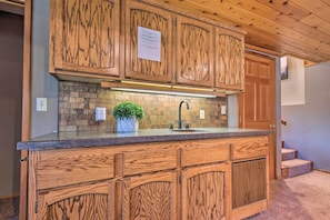 Kitchen features an island with a granite countertop and stainless steel sink.