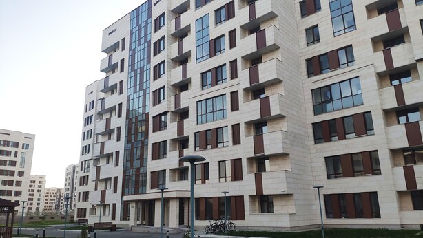 Ein mehrgeschossiges Wohngebäude mit moderner Architektur, mit Balkonen und großen Fenstern.