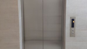 Ein geschlossener Aufzug, dessen digitales Display die Zahl 4 anzeigt.