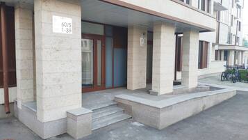 Entrada de un edificio con un letrero que indica la disponibilidad de estacionamiento.