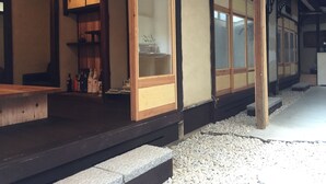 En traditionell japansk byggnad med träbjälkar och golvbeläggning av tatamimattor.