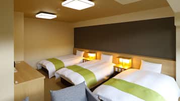 Quarto de hotel com duas camas, uma escrivaninha e uma cadeira.
