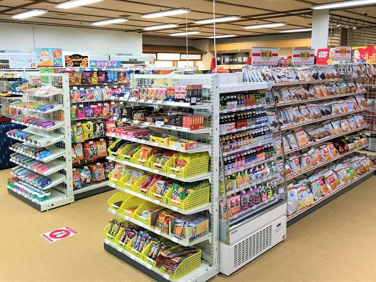 En hyllgång i en livsmedelsbutik, där hyllorna är fyllda med olika sorters förpackade varor och snacks.