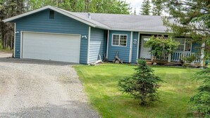 A single-story house with a garage, a front porch, and a small front yard. - Alaskan Cozy Home for the Whole Family and Friends (Sterling)