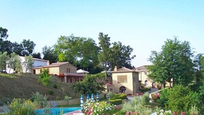 A residential area with houses, a swimming pool, and well-maintained gardens. - Lovely apartment in villa for 2 people with WIFI, pool, TV and patio, close to San Gimignano (Volterra)